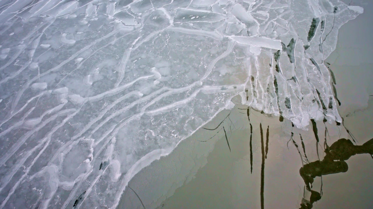 Riprese aeree con drone che catturano formazioni di ghiaccio astratte sulla superficie ghiacciata del Lago Michigan.