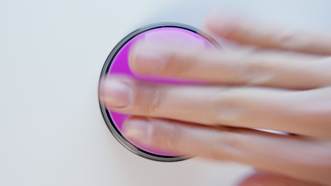 joven presionando el botón púrpura con un dedo y la palma de la mano. presiona un botón redondo brillante, vista superior. activación, lanzamiento de algo. encender y apagar.