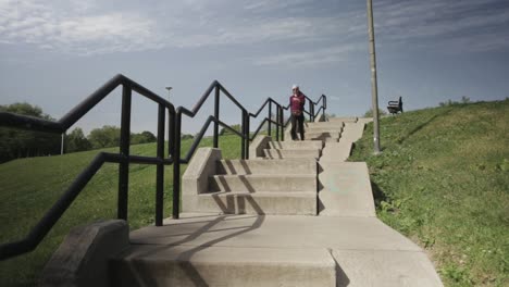 a young woman working out outdoors walking in a stairway - medium shot