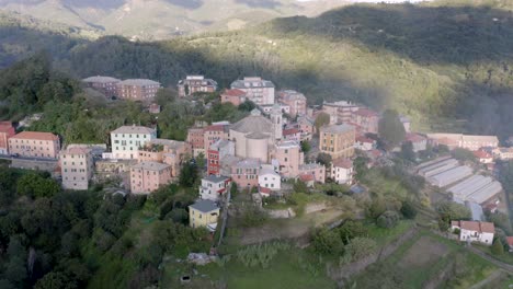 Vista-Aérea-De-Un-Pequeño-Pueblo-A-Través-De-Las-Montañas-En-Italia