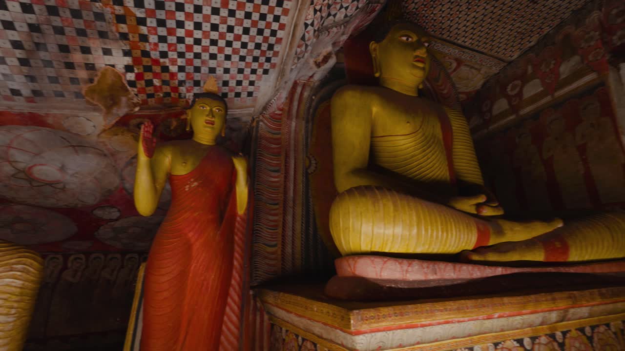 Statue dorate di Buddha presso lo storico Tempio Rupestre di Dambulla, Sri Lanka. Affreschi e arte sacra.