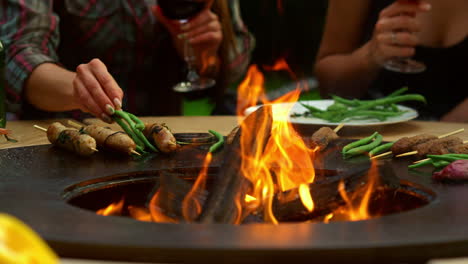 unrecognizable woman grilling sausages in backyard