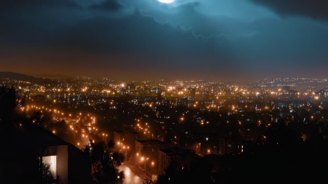 Noční panorama města pod bouřkovými mraky se zářícími světly. Městská záře kontrastuje s tmavou oblohou a siluetami stromů. Atmosféra působí dramaticky a filmově.