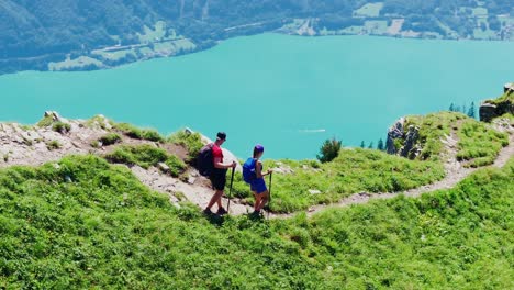 couple hikes down hardergrat trail in slow motion, swiss alps, brienzersee lake