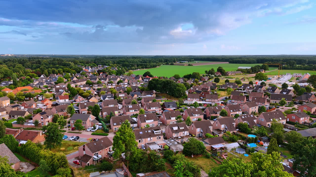 Similar houses in the residential area of Overloon, Netherlands. Beautiful green forests and meadows around the town. Aerial view