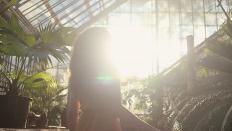 young girl model whirling around in tropical greenhouse