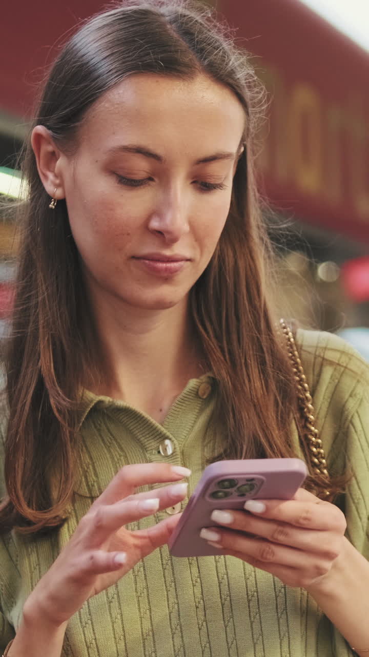 Young Woman Using Smartphone Outdoors, Scrolling and Looking Up