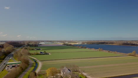 Aerial-drone-view-of-the-beautiful-wide-farm-fields-near-the-lake-in-the-Noordwijk,-the-Netherlands