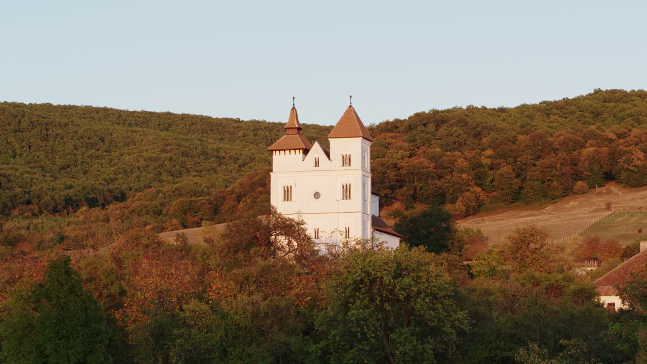 Aerial Shot of Herina, Romania White Church in Hilly Transylvanian Village