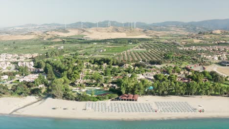 Aerial-view-of-beautiful-sea-and-beach-with-parasol-at-sunny-day,-Simeri-Mare,-Calabria,-Southern-Italy