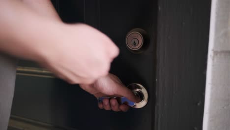 close-up static shot of male hands unlocking a storage room door with keys and opening for entry