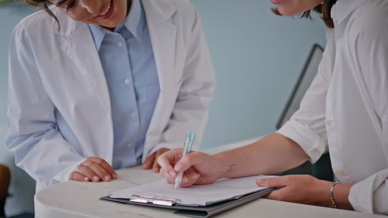 Doctor hands signing documents in healthcare office closeup. Woman practitioner