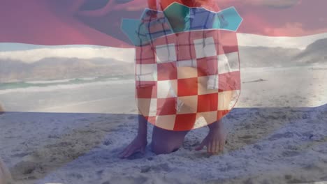 animation of flag of croatia over caucasian family at beach