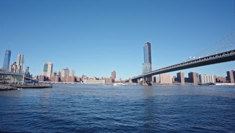 Pan-shot-between-Manhattan-and-Brooklyn-bridges-over-East-River,-New-York-City