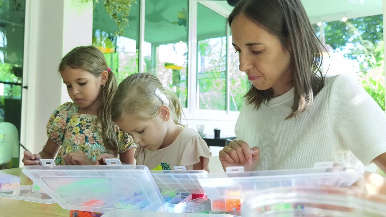 어머니와 딸들이 함께 공예를 하고 있습니다.