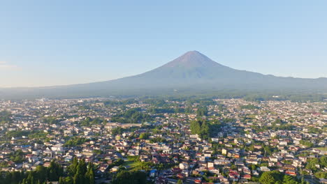 aerial panning tilt shot of the fujikawaguchiko town with mt fuji backdrop, japan