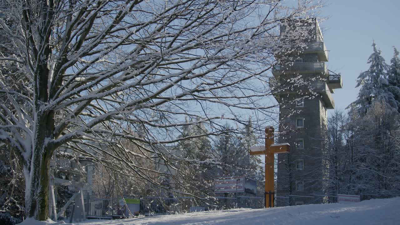 Beautiful Winter Snowy Landscape with Tree Snow falling down behind Wood Cross Religious Brick Tower