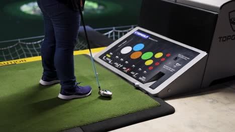 person preparing to hit golf ball at range