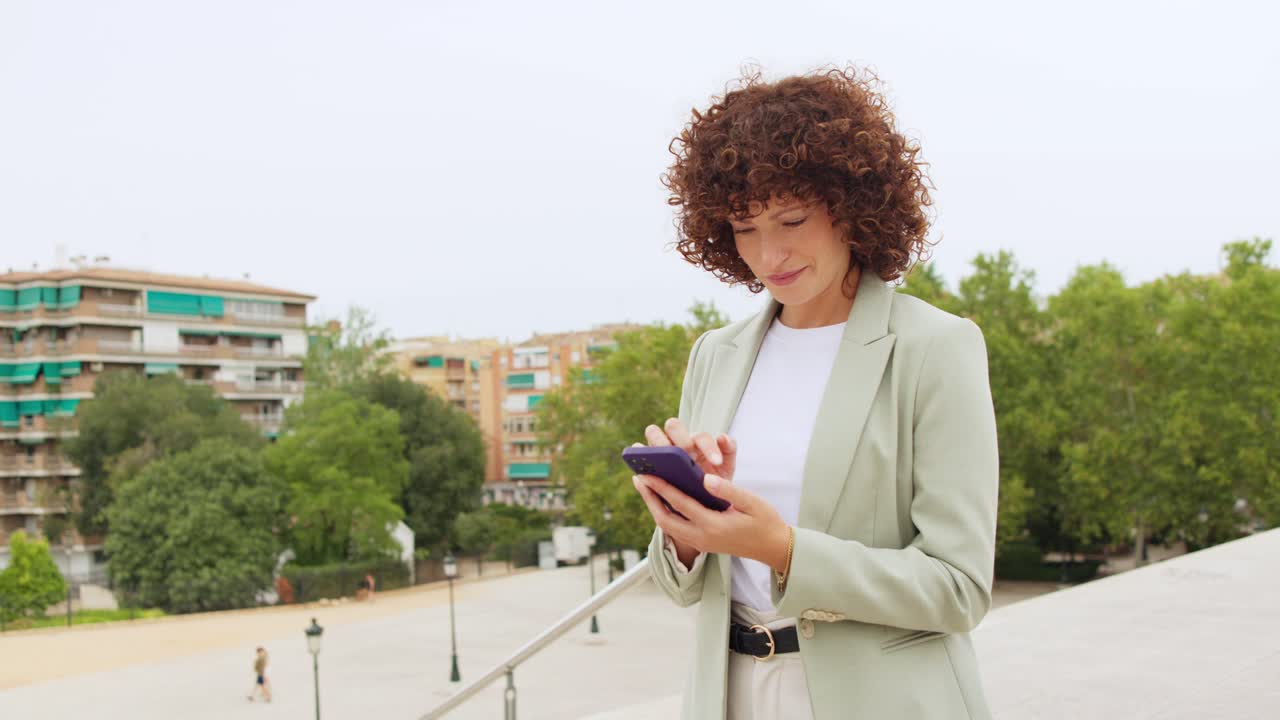 Donna che per mezzo del telefono all'aperto