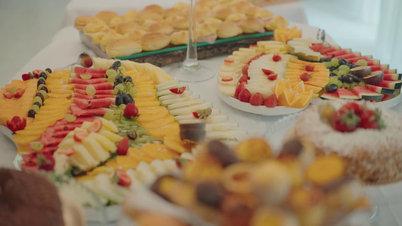 화려한 연회 테이블에 슬라이스한 과일과 디저트가 다채롭게 진열되어 있어요