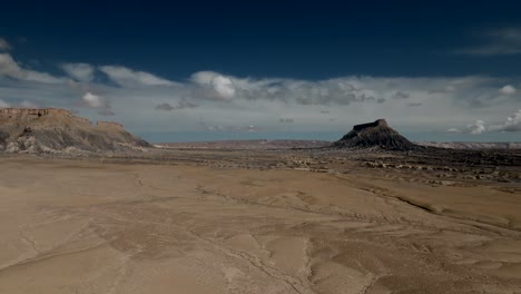 factory butte rises above the barren caineville desert basin - pullback aerial view