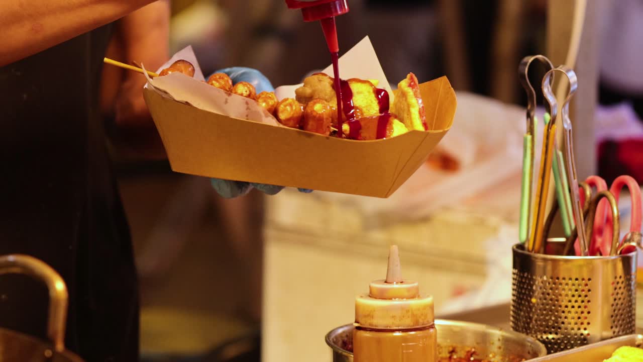 vendedor prepara y sirve un plato de comida callejera