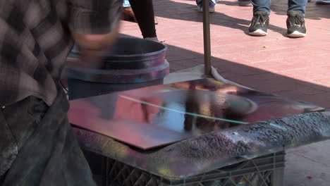 this is a closeup shot of a spray paint artist as he creates a beautiful piece of art using cans of spray paint