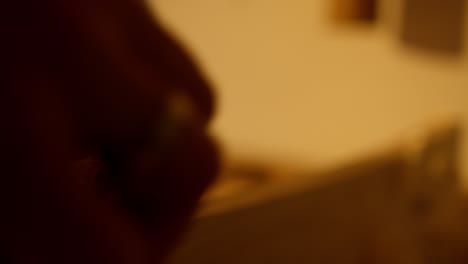 close-up of the hand of a person sanding a wooden board in a workshop