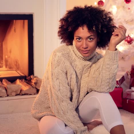 woman by fireplace and white christmas tree