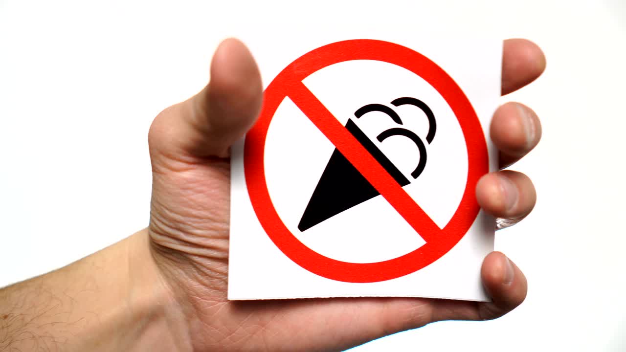 No ice creams allowed sign isolated. Male hand showing warning sign