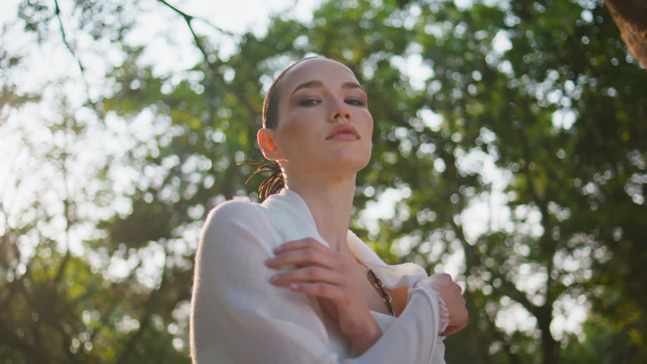 mujer glamurosa posando parque verde naturaleza mirando cámara de cerca. señora relajante