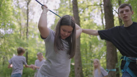 in the summer camp my daughter learns to overcome rope obstacles and rock climbing. teaching children about tourism and hiking