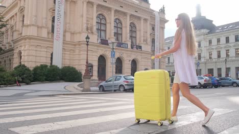 young female traveler walking with a luggage on the city street. arriving to the city while travel. beautiful tourist girl travels