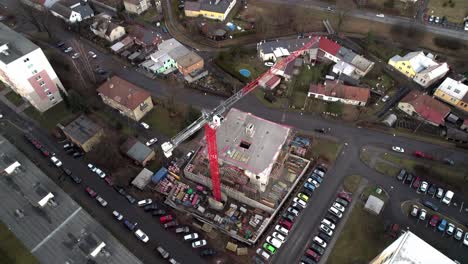 aerial bird's eye view of construction work underway with a crane and cars parks all around the location in jerab, czech republic,europe on a sunny morning