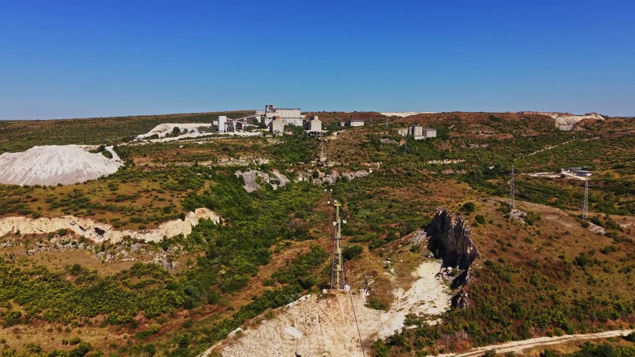 Persone su una zip line sopra un paesaggio con vegetazione ed edifici