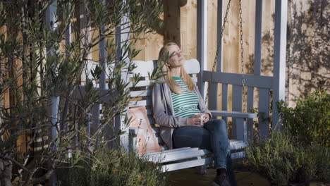 woman relaxing on a swing in the garden