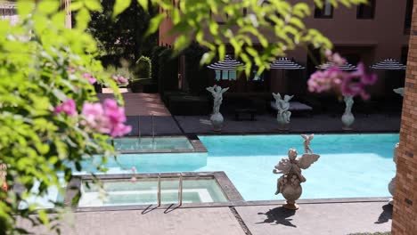 statue near pool surrounded by greenery