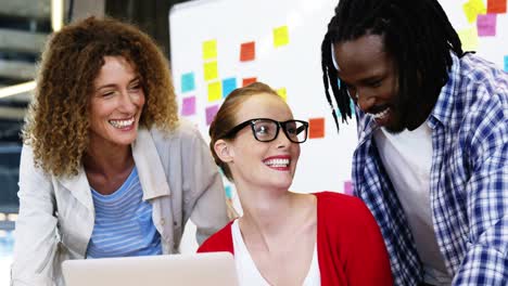 Happy-executives-talking-while-working-on-the-laptop