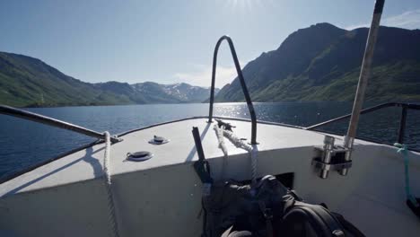 boat cruising through the lake with scenic mountains in norway - pov shot