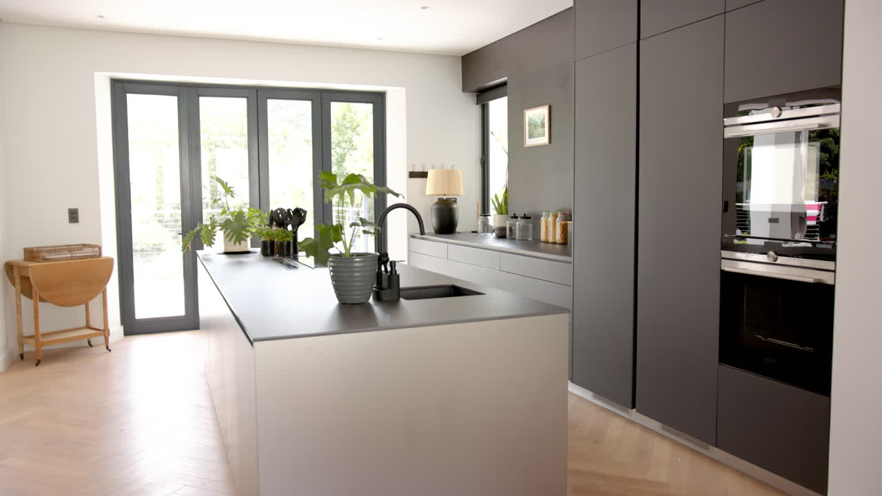 A modern kitchen features sleek gray cabinetry and a central island with a sink