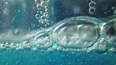 large and small bubbles fall slowly in blue liquid, fluid background