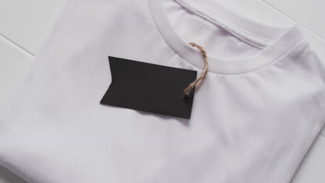 video von einem flachen weißen t-shirt mit tag und kopierraum auf weißem hintergrund