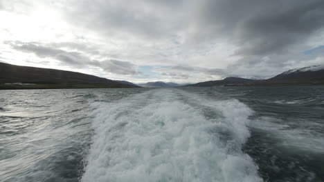 foam behind a boat in iceland. cloudy day