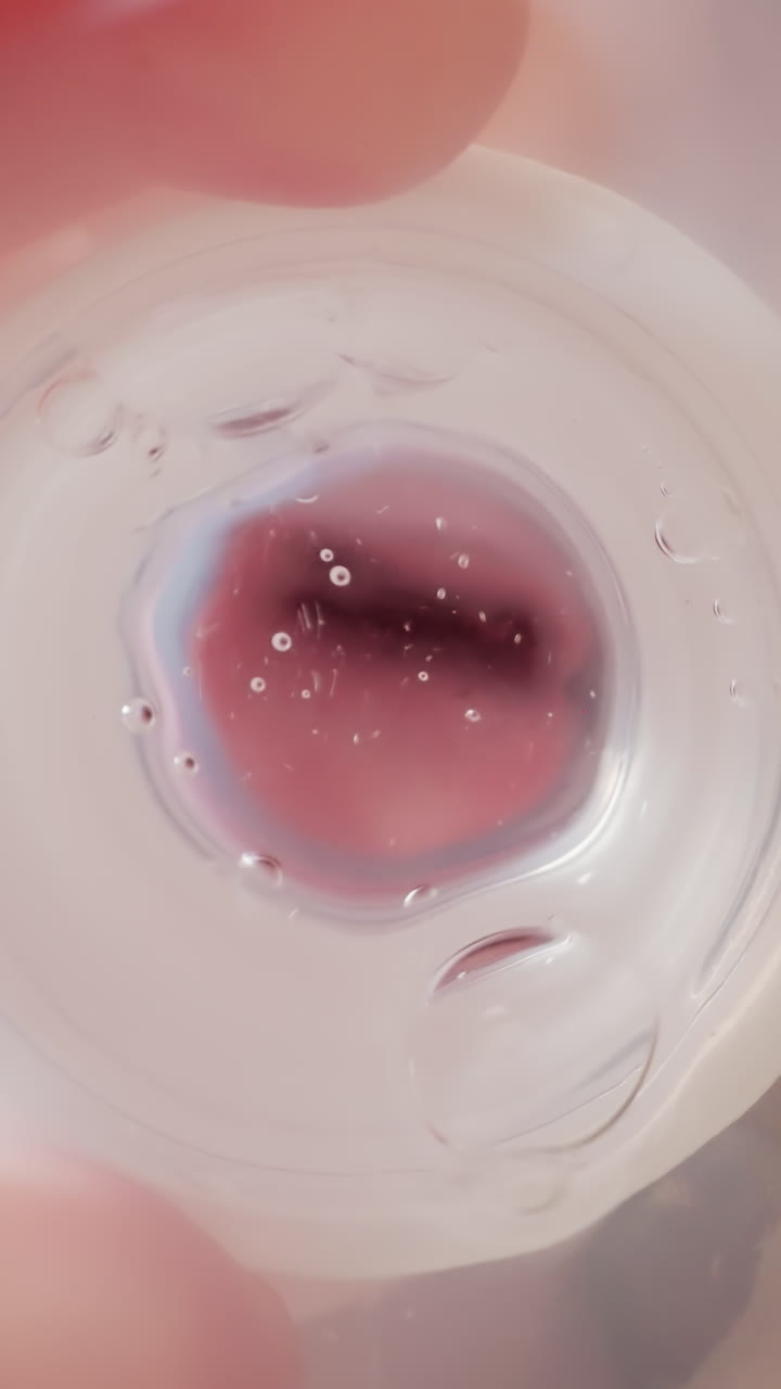 Little boy drinks water holding plastic bottle with nipple. Child tilts bottle and air bubbles form. Preschooler puts bottle under white ceiling macro low angle shot