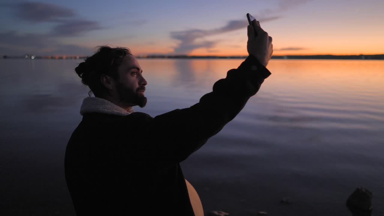 Man Taking a Selfie at Sunset over a Lake