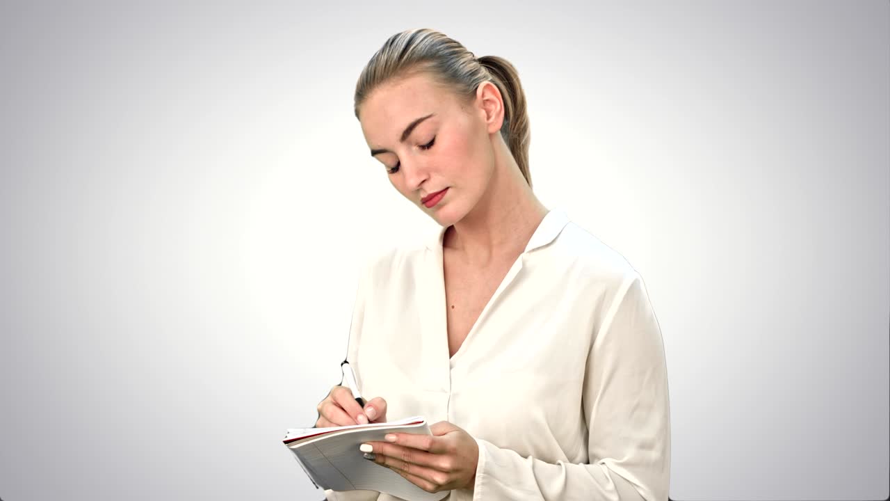 joven mujer de negocios inventando ideas, escribiendo, hacia abajo en el cuaderno sobre fondo blanco