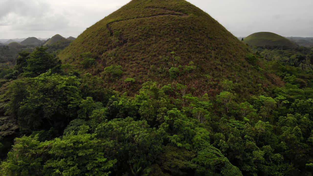 inclinación aérea revela colinas de chocolate con cielo dramático en bohol, filipinas 4k
