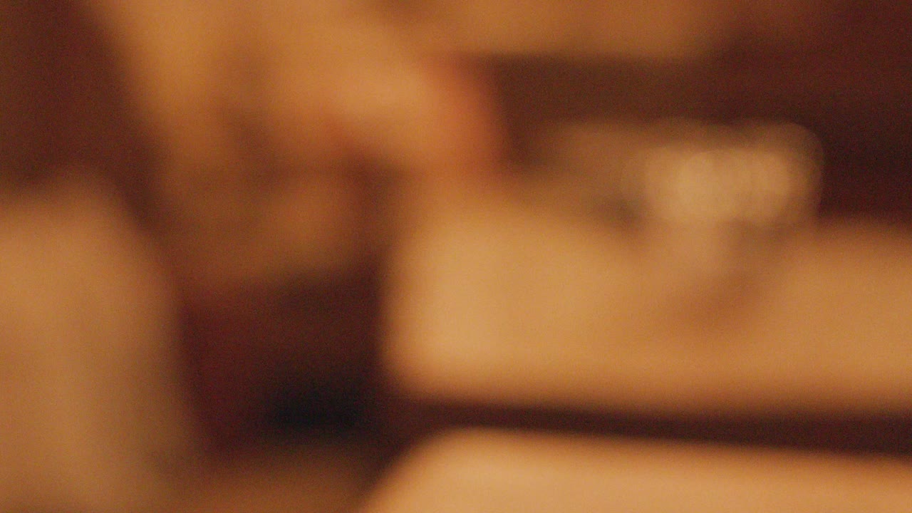 Pint of dark stout beer on wooden pub table, warm lighting, shallow focus, cinematic feel