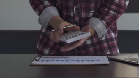 concepto de finanzas y economía cuentas de gastos mensuales y liquidación de deudas jóvenes usan calculadoras. cuentan sus ingresos domésticos y documentos fiscales en casa.