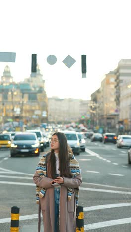 young woman with coffee enjoying a sunny day on a city street